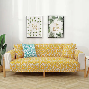 Housse de canapé matelassée une pièce avec motif feuilles et sangles élastiques antidérapantes