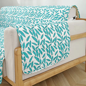 Housse de canapé matelassée une pièce avec motif feuilles et sangles élastiques antidérapantes