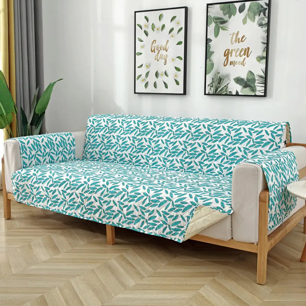 Housse de canapé matelassée une pièce avec motif feuilles et sangles élastiques antidérapantes