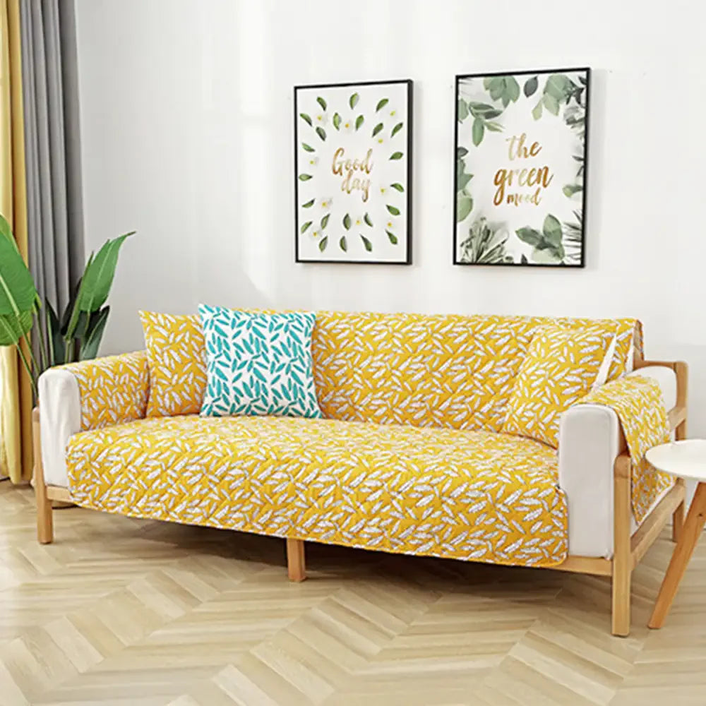 Housse de canapé matelassée une pièce avec motif feuilles et sangles élastiques antidérapantes
